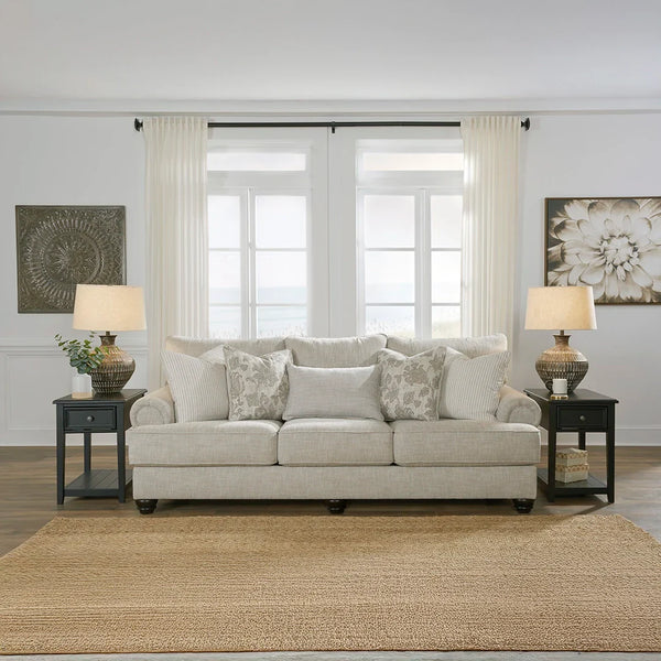 Light-hued textured sofa with distinctive roll arms and plush cushions.