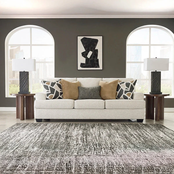 Neutral contemporary sofa with clean lines, curved arms, and accent pillows – Ashley UAE.