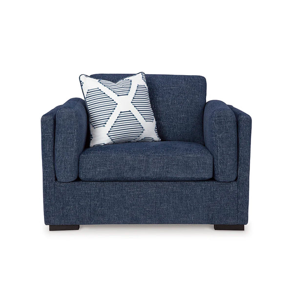 Side view of navy oversized chair with bolster pillows and accent cushion