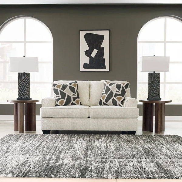 Contemporary loveseat with clean lines, curved details, and neutral polyester upholstery.